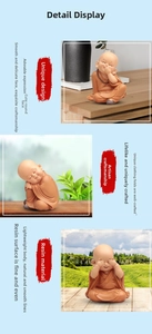 Three cute resin monk figurines in orange robes posing in a serene zen garden setting