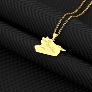 Detailed macro view of the golden Syria map pendant with engraved city names and link chain