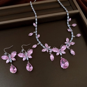 Makroansicht von Halskette und Ohrringen mit rosa Zirkonia und Schmetterlingsanhängern