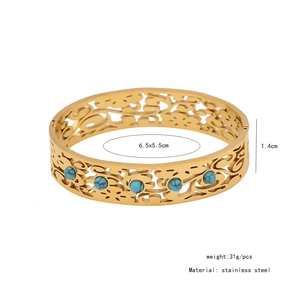 Detail view of vintage stainless steel bangle with turquoise inlay and hollowed patterns
