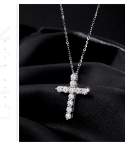 Close-up of sparkling moissanite cross pendant with S925 silver chain on black leather
