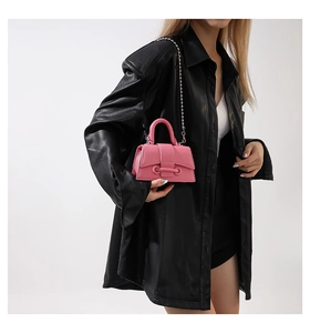 Close-up of pink mini crossbody bag with leather texture and silver chain strap details
