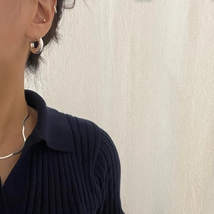 Polished 925 sterling silver hoop earrings and wavy necklace shown on a model