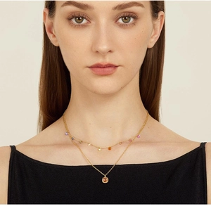 Close-up of model wearing double-layered 18K gold-plated rainbow gemstone necklace