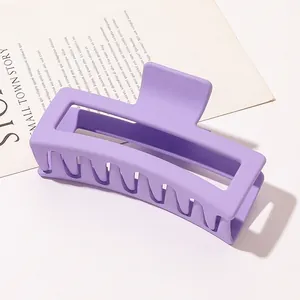 Macro view of a large matte purple rectangular claw clip for thick hair styling