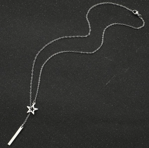 Macro shot of silver minimalist necklace featuring hollow star and vertical bar charms