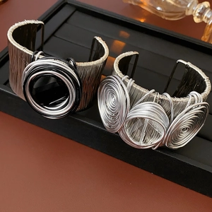 Macro detail of multilayer silver metal wire bracelets with spiral disc decorations