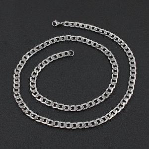 Detail of silver stainless steel Cuban link necklace with lobster clasp on black texture