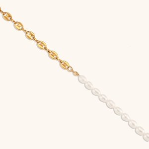 Detail of a gold pig nose chain spliced with baroque pearls in a trendy necklace design