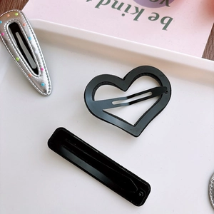 Detail of silver drop clips with colorful dots and black geometric hair accessories