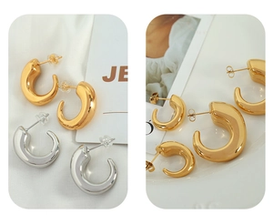 Macro detail of 18K gold and silver hollow C-shaped earrings with high polish finish