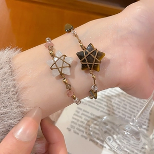 Detail of hand-woven ethnic bracelets with star-shaped tiger eye and crystal gemstones