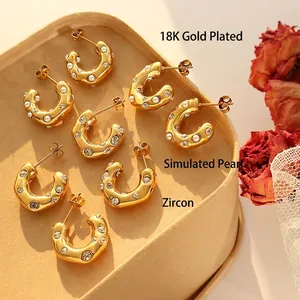 18K gold plated C-shaped earrings with imitation pearls and zircons on a jewelry box