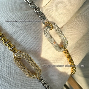 Macro detail of two-tone chain necklace with pave-set diamond oval link pendant