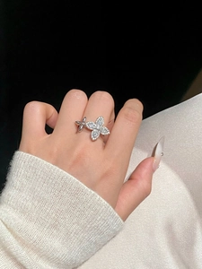 Detailed view of silver flower ring with zircon stones on a model finger