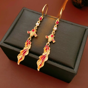 Macro detail of vintage goldfish enamel earrings with pearl accents and golden fish hooks