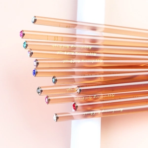 Macro detail of amber nail brushes with sparkling colorful rhinestone tip embellishments