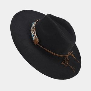 Macro detail of black wool fedora with ethnic woven band and turquoise star bead accent