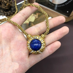 Detail of vintage gold-plated necklace with lapis lazuli pendant and clear crystal halo