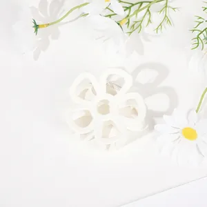 Close-up of a white flower hair claw clip with a hollow five-petal floral design