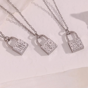 Detailed view of silver stainless steel lock pendants with gothic letters and water droplets