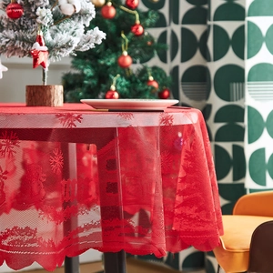 Red Christmas lace tablecloth featuring festive snowflakes and trees on a round dining table