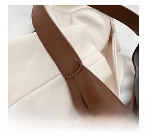 Close-up of precise stitching and premium leather texture on brown tote shoulder bag