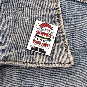 Christmas Nurse themed rectangular metal brooch pinned on denim jacket with Santa text