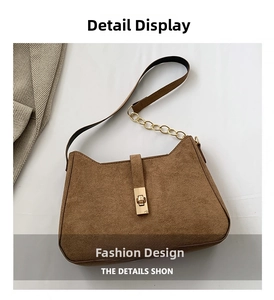 Close-up of brown faux suede shoulder bag with golden metal twist lock and chain strap