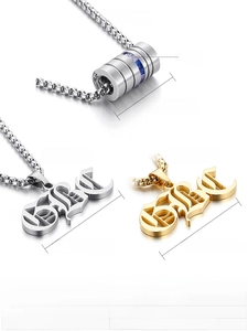 Macro shot of stainless steel dumbbell pendants in gold and silver with blue zircon inlay