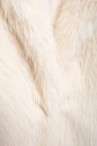 Close-up macro of white faux fur texture showing soft fluffy fibers and dense coat detail