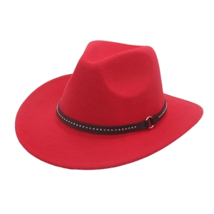 Détail d'un chapeau de cowboy rouge avec ceinture en cuir noir à rivets