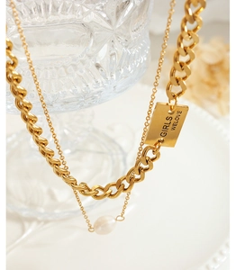 Close-up of double-layer gold necklace with freshwater pearl and engraved square pendant