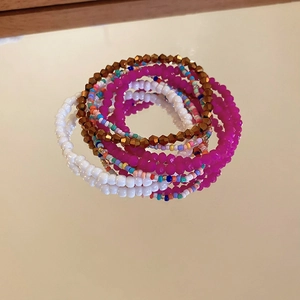 Close-up of bohemian stacked colorful bead bracelets with reflective mirror details
