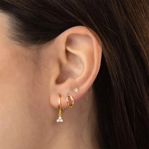 Close-up of minimalist gold S925 sterling silver hoop earrings set worn by a model
