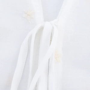 Haut blanc de style français avec broderie florale et détails de laçage au col en V