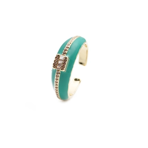 Macro detail of emerald enamel ring featuring gold-plated texture and sparkling zircon