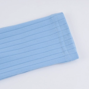 Vue macro du tricot côtelé bleu clair avec couture détaillée à double aiguille sur l'ourlet