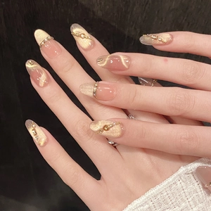 Handmade cat-eye press-on nails in champagne gold and nude pink with rhinestones