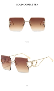 Detail of rimless square sunglasses with gold heart-shaped temples and brown gradient lenses