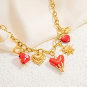 Détail du collier plaqué or 18k avec pendentifs cœurs en émail rouge et couronne