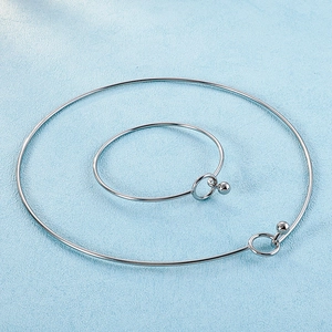 Flat lay of a minimalist polished silver jewelry set with necklace and matching bangle