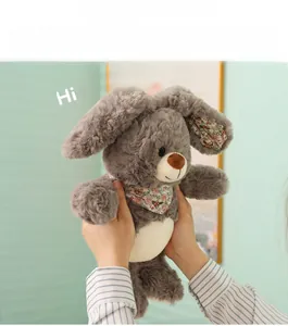 Detalle de conejo de peluche con motivos florales y suave piel gris sostenido a mano