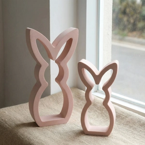 Ensemble de moules lapin rose mat minimaliste sur lin sous une douce lumière naturelle
