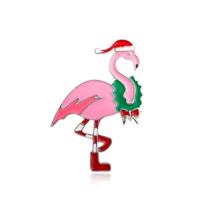 Cute pink enamel flamingo brooch wearing a red Santa hat and festive green wreath