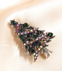 Close-up of vintage gold Christmas tree brooch with emerald green and AB crystals