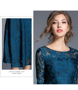 Detail of teal lace dress featuring vintage floral patterns and sheer mesh sleeves