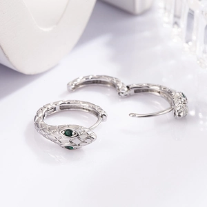 Close-up of silver snake earrings with green zircon eyes and engraved S925 hallmark