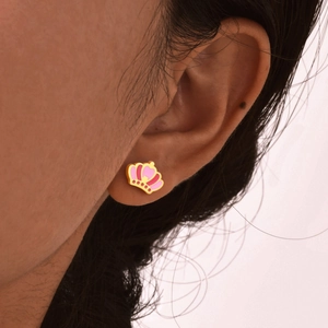 Close-up of a pink crown stud earring in gold finish worn on a female ear lobe