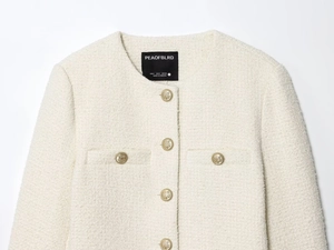 Détail du col en tweed blanc avec boutons dorés à ancre et étiquette de marque au cou